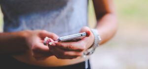 Wir tauschen uns aus! Zu sehen ist auf dem Bild eine Frau mit einem Smartphone in der Hand. Foto @ Kaboompics