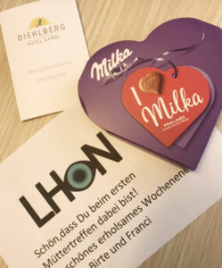 das Bild zeigt die Visitenkarte des Vereins und des Hotels, sowie ein Milka-Schoko-Herz