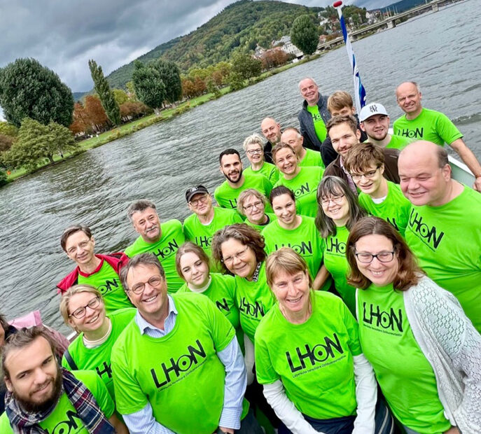 Bild der Teilnehmer vom LHON Jahrestreffen 2022 in Heidelberg, im Hintergrund ist der Neckar zu sehen. Das Gruppenbild entstand auf dem Schiff.